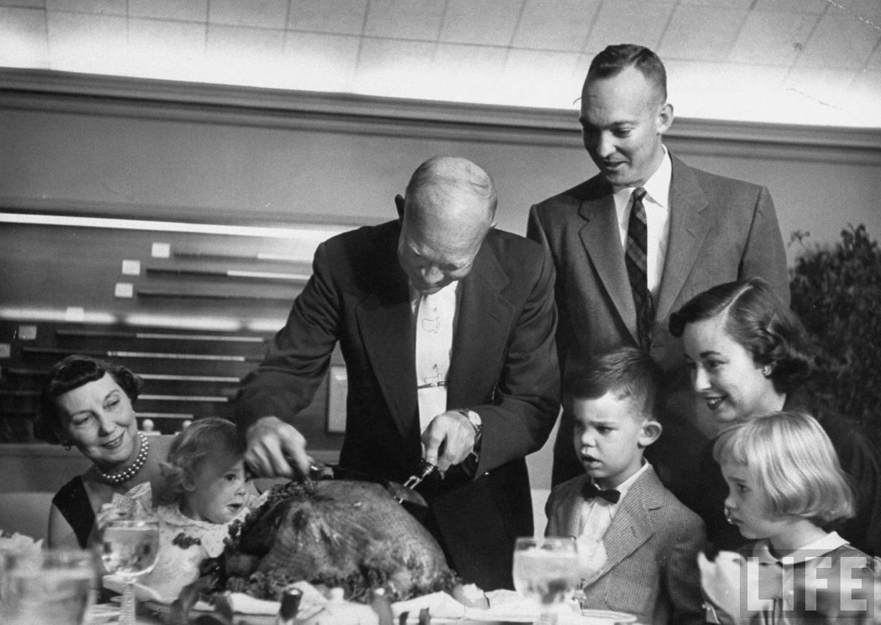 President Dwight D. Eisenhower carving the Thanksgiving turkey while Mamie, John & the rest of the family are cheerfully looking on.Photographer:George Skadding. © Time Inc